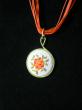 Médaillon en broderie orange jaune et rouge sur tissu blanc, cordon organdi et coton ciré orange. Diamètre 30mm. longueur 42cm;