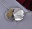 description: Pendentif en argent massif avec un motif en or jaune 18k.
