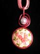 Médaillon brodé,camaieu de roses sur fond blanc, perle cirée et tour du cou en organza et coton ciré., diamètre 30mm, longueur 42cm 