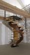 Escalier métallique demi tournant avec son limon central débillardé, ses marches en chêne et ses gardes corps acier et inox.