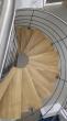 Escalier métallique demi tournant avec son limon central débillardé, ses marches en chêne et ses gardes corps acier et inox.