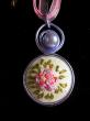 Médaillon brodé,camaieu de roses sur fond blanc, perle cirée et tour du cou en organza et coton ciré., diamètre 30mm, longueur 42cm 