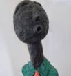 Sculpture artisanale en papier mâché,”Le Dandy Silencieux”incarne une élégance singulière et poétique. Sa silhouette allongée, vêtue d’un costume vert texturé à pois et d’une cravate orange éclatante, évoque un personnage discret mais affirmé, figé dans une posture contemplative.
Son visage sobre et sans expression détourne le regard, comme absorbé par un monde intérieur. L’équilibre entre les couleurs, les formes et les matières donne à cette oeuvre une dimension à la fois naïve, graphique et profondément humaine.

Pièce unique faite main.