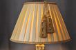 L’abat-jour EMPIRE est un modèle d’exception qui habille avec élégance un salon, une salle à manger, un bureau ou une entrée.

Sa forme classique s’adapte à de nombreux pieds de lampe, notamment de style colonial ou Empire. Son plissage manuel en taffetas de soie, réalisé dans la pure tradition des abat-jour couture, lui confère une allure à la fois sobre et raffinée. Un fin galon souligne délicatement le haut et la base, ajoutant une touche de sophistication.

Caractéristiques :
Matière : taffetas de soie plissé à la main

Coloris disponibles :

Soie : café glacé ou blanc cassé

Doublure : or clair ou blanc cassé

Galon : or ou blanc cassé

Dimensions disponibles : (cercle bas x cercle haut x pente)

XS : 25 x 13 x 19 cm
S : 30 x 18 x 21 cm
M : 35 x 20 x 25 cm

L  : 40 x 22 x 28 cm

Parfait par paire, il sublimera une cheminée, un grand miroir ou une entrée en apportant une lumière chaleureuse et élégante.

Fabrication & Personnalisation
Chaque abat-jour est confectionné entièrement à la main dans notre atelier en Auvergne. Son plissage artisanal garantit un rendu unique, avec de légères variations qui font le charme du fait main.

Personnalisation sur demande : possibilité de le réaliser dans d’autres dimensions. Contactez-nous pour toute demande spécifique.